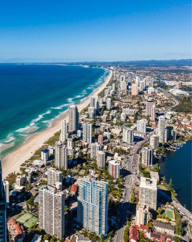 Coastal city skyline with high-rise buildings and ocean.