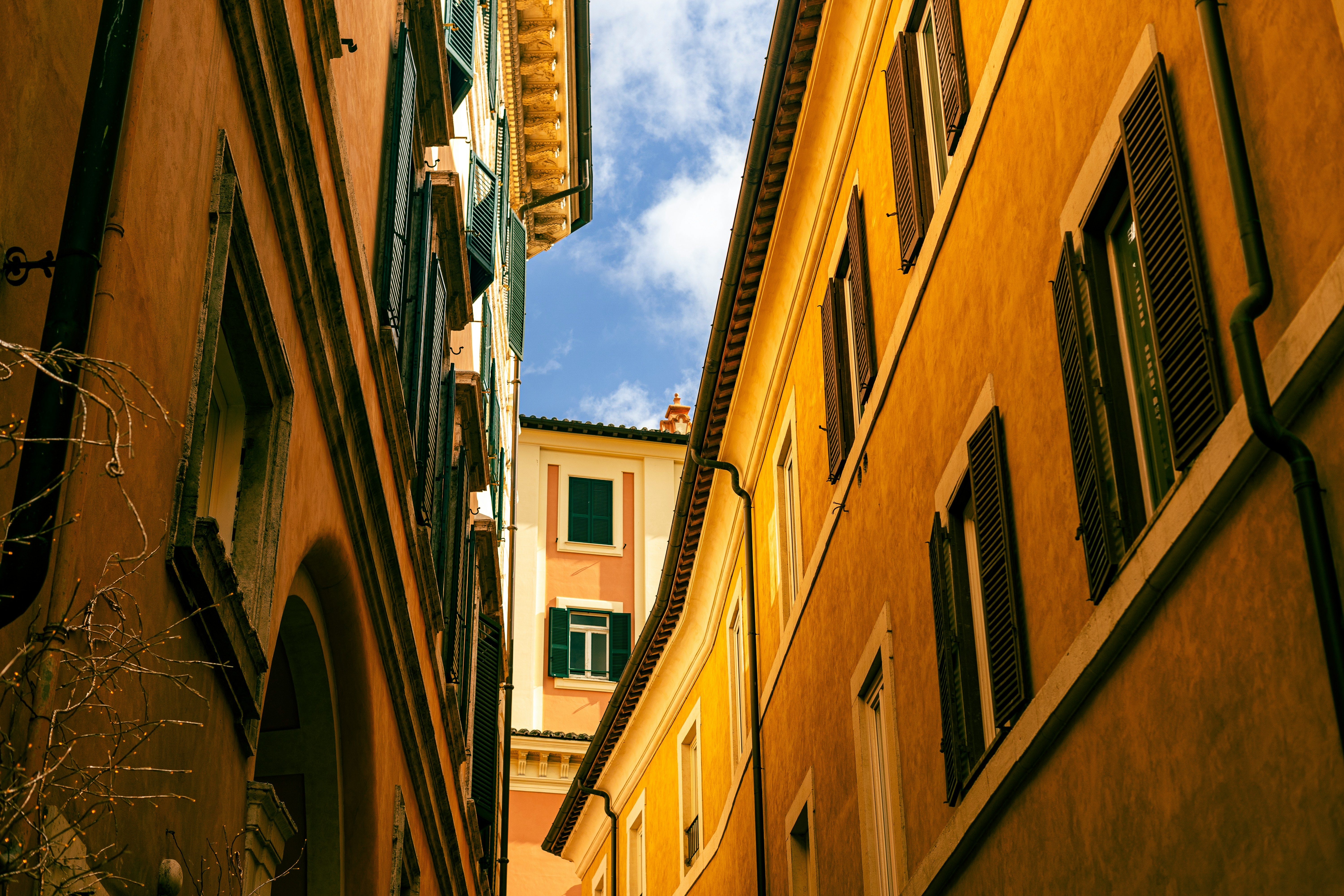 Buildings in an alleyway frame a strip of sky.