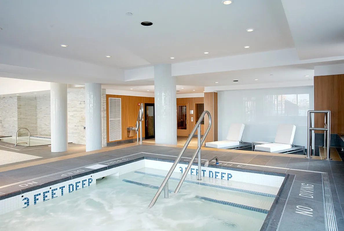 A spacious indoor hot tub situated in a contemporary building, featuring sleek design and inviting water.