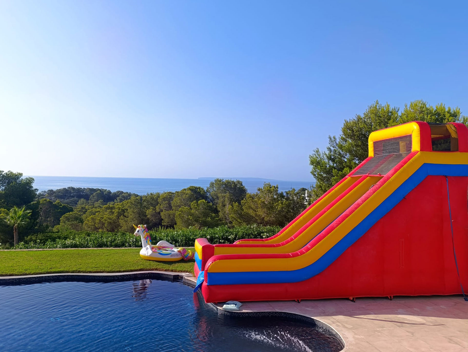 Inflatable water slide at pool, luxury villa Ibiza events private VIP retreat.