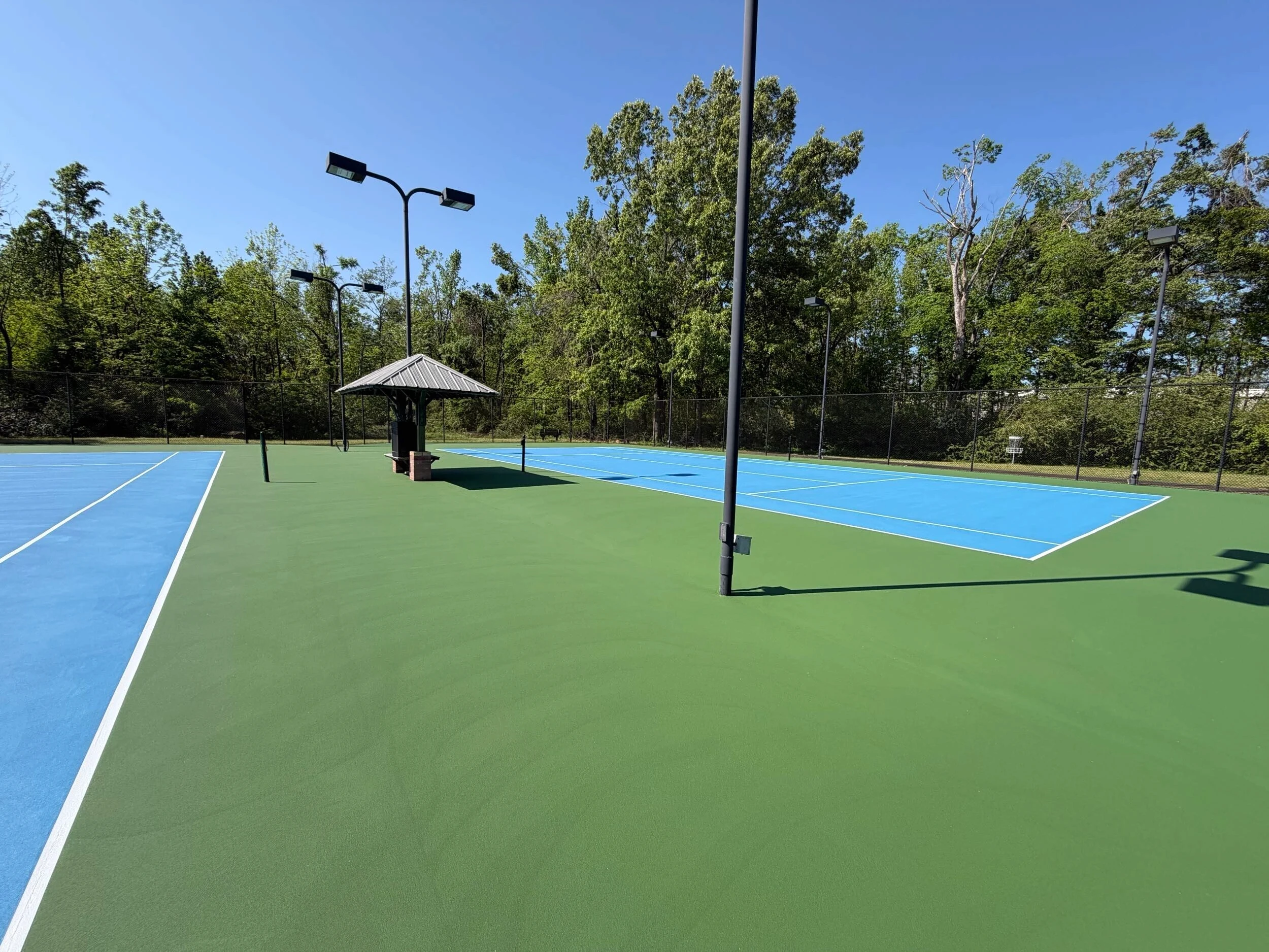 Completed tennis and pickleball court resurfacing with fresh blue and green coatings in Corinth, MS