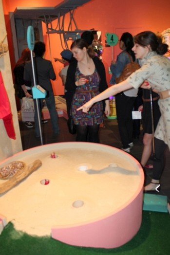 two girls looking at the installation of a sculpture