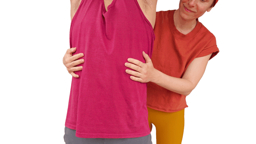 Teacher’s hands wrapped around the sides of a student’s ribcage as he reaches his arms overhead