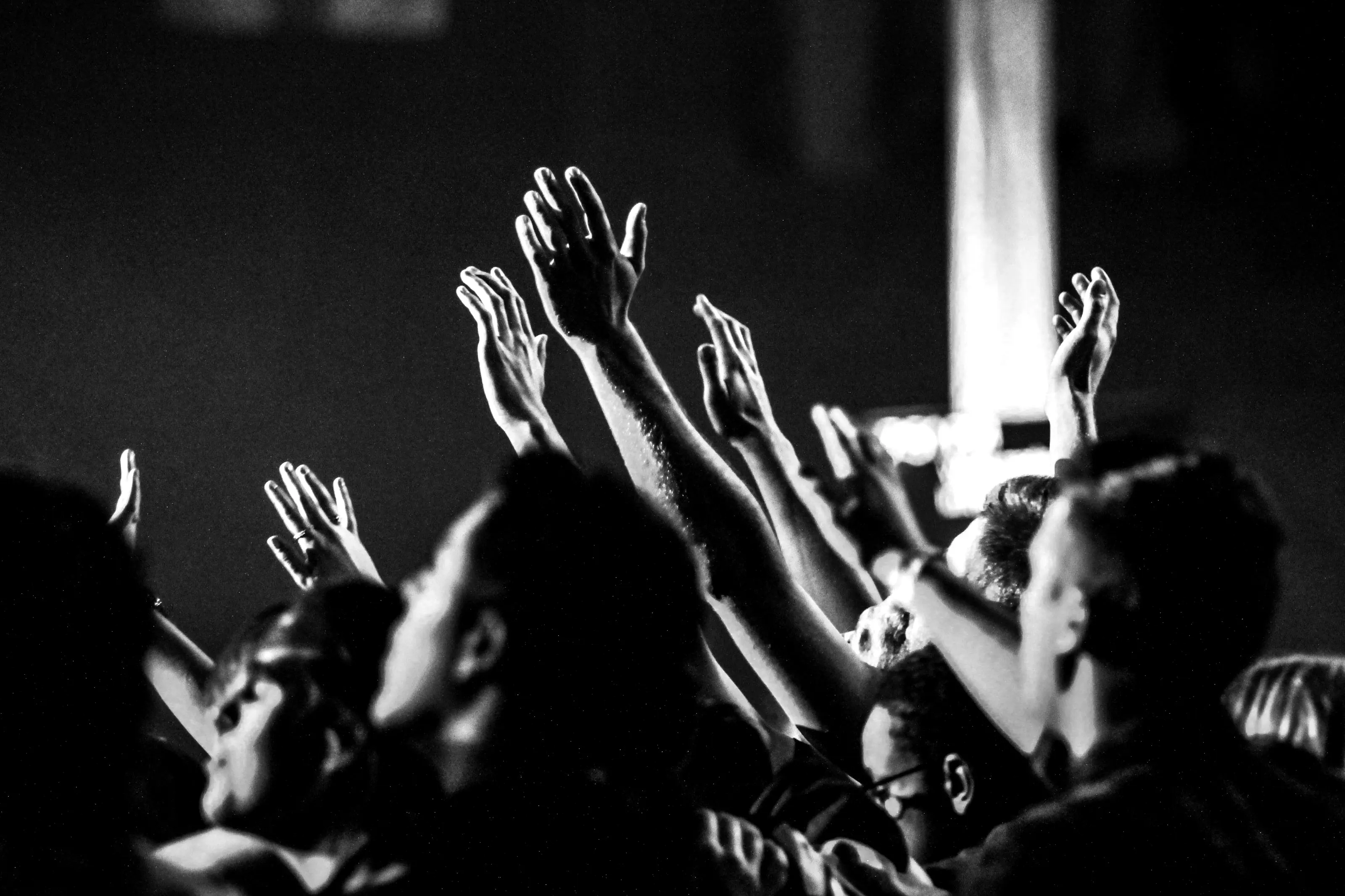 People raising their hands during worship at Confluence Church