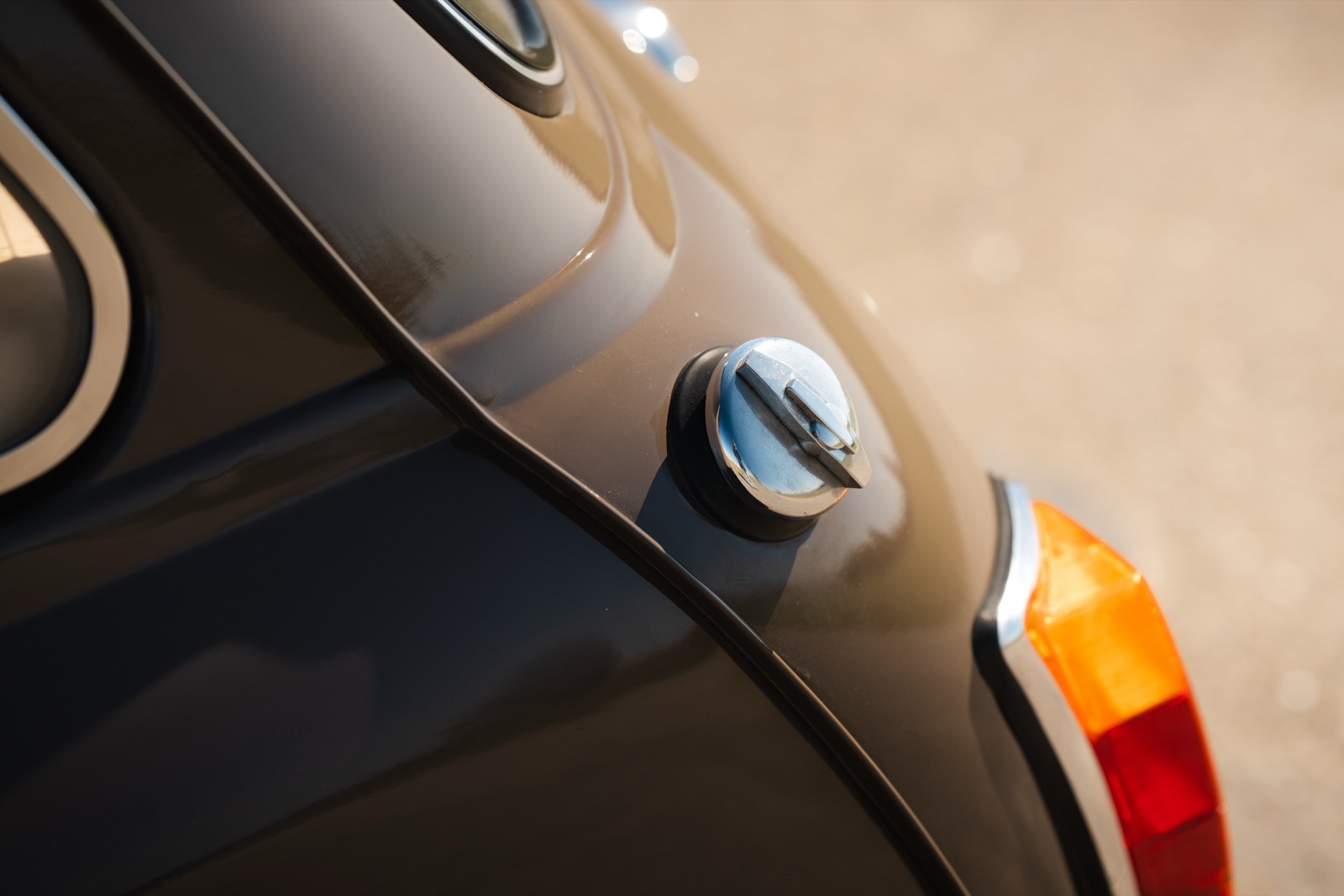 Close-up of a vintage car's rear detail, focusing on the fuel cap and adjacent taillight.