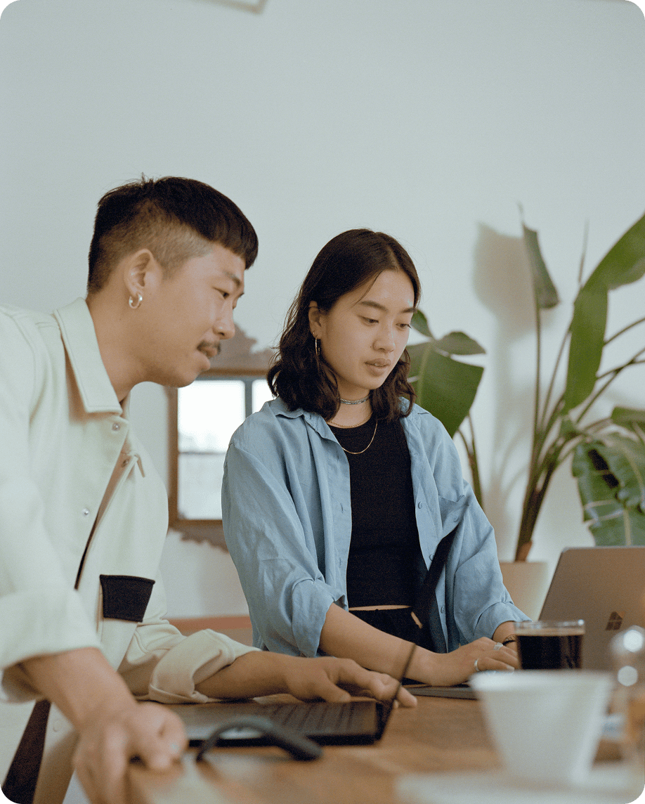 Two colleagues reviewing work together at a desk