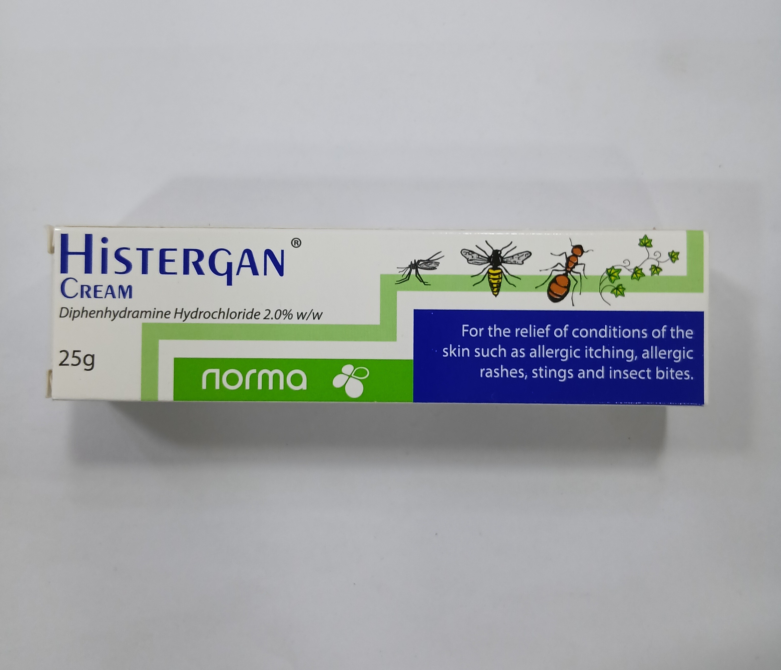 White rectangular cardboard packaging displays green and white text and graphics, including an illustration of insects and plants, with a 25-gram cream tube partially visible.