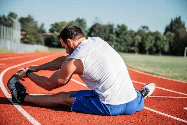 Man stretching on an outdoor running track