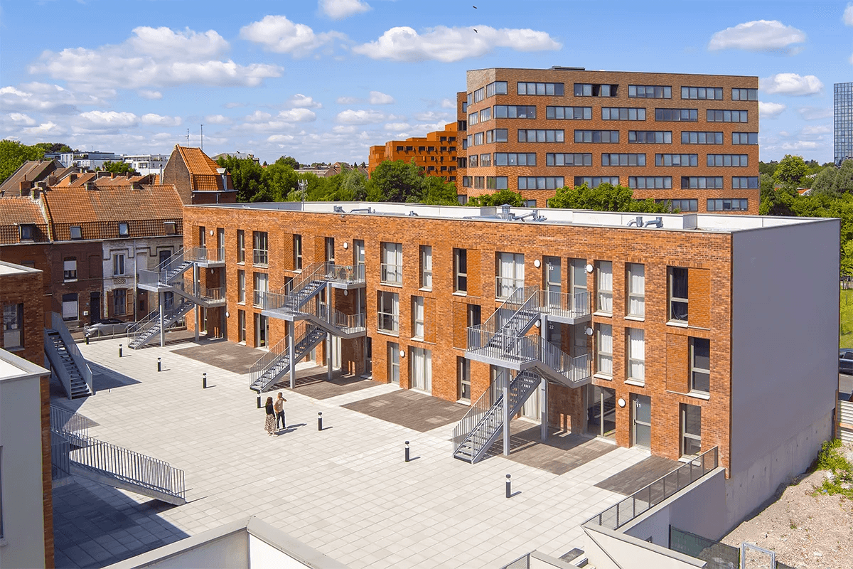 Immeuble moderne en briques rouges avec des escaliers extérieurs en métal. Vue extérieure d'un quartier résidentiel clésence à Roubaix