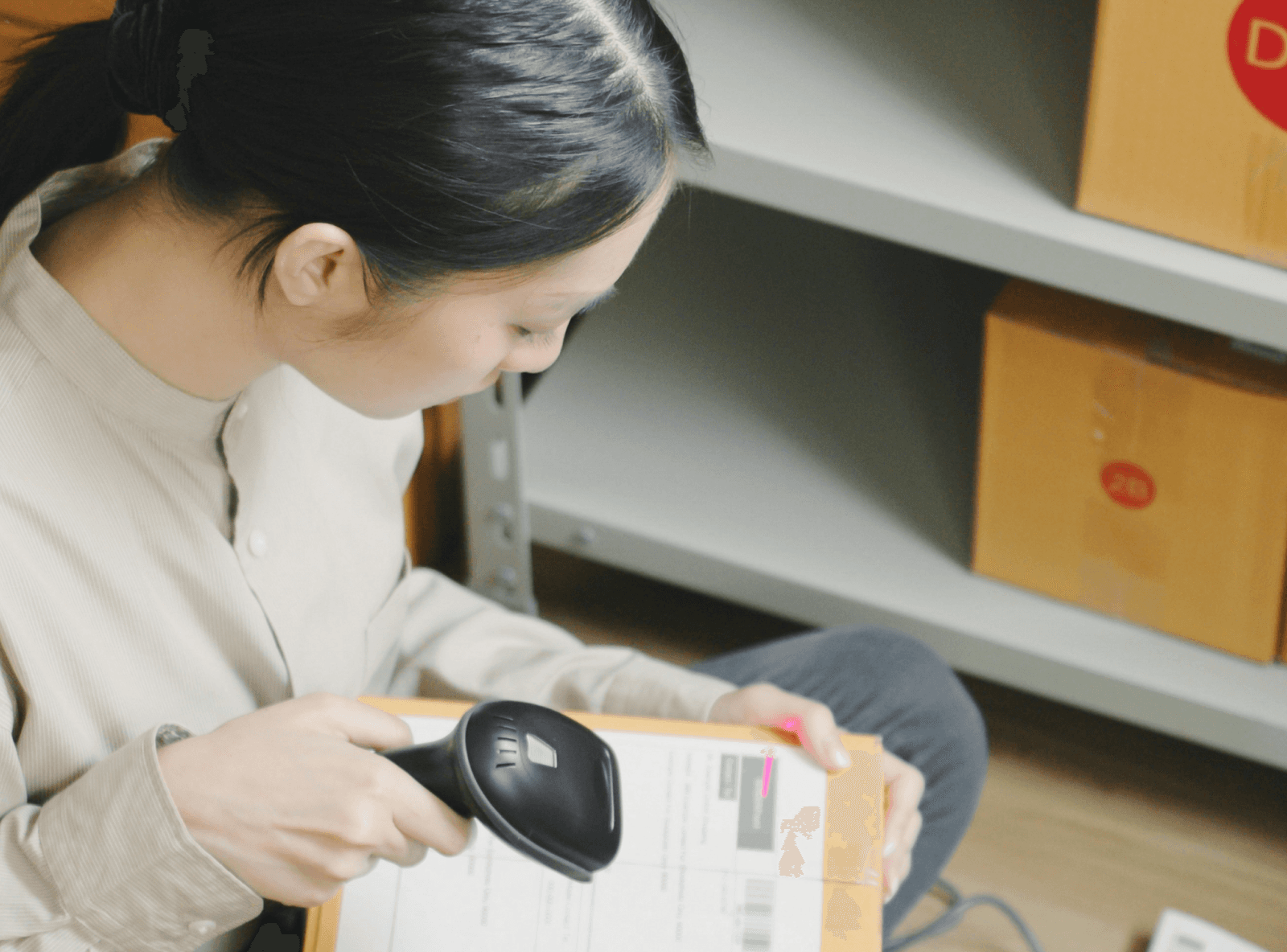 E-commerce worker scanning box close-up on warehouse floor