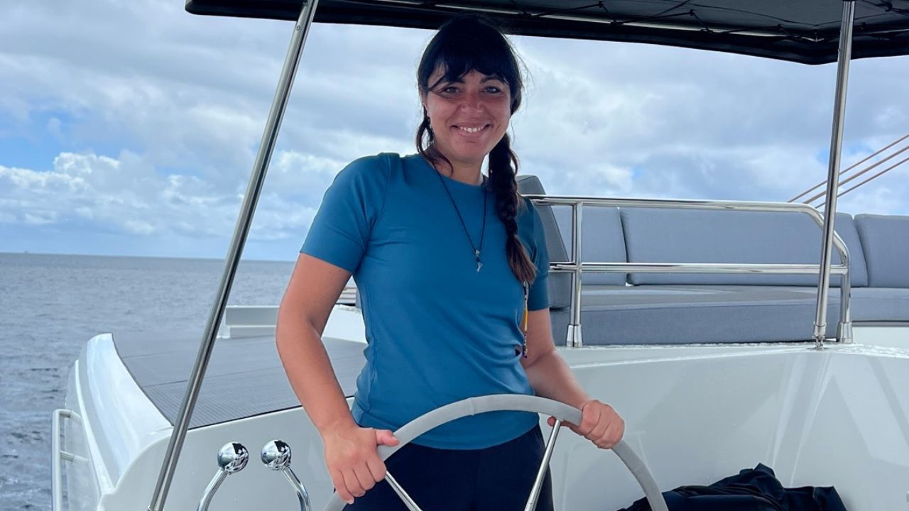 A woman at the helm of a sailboat