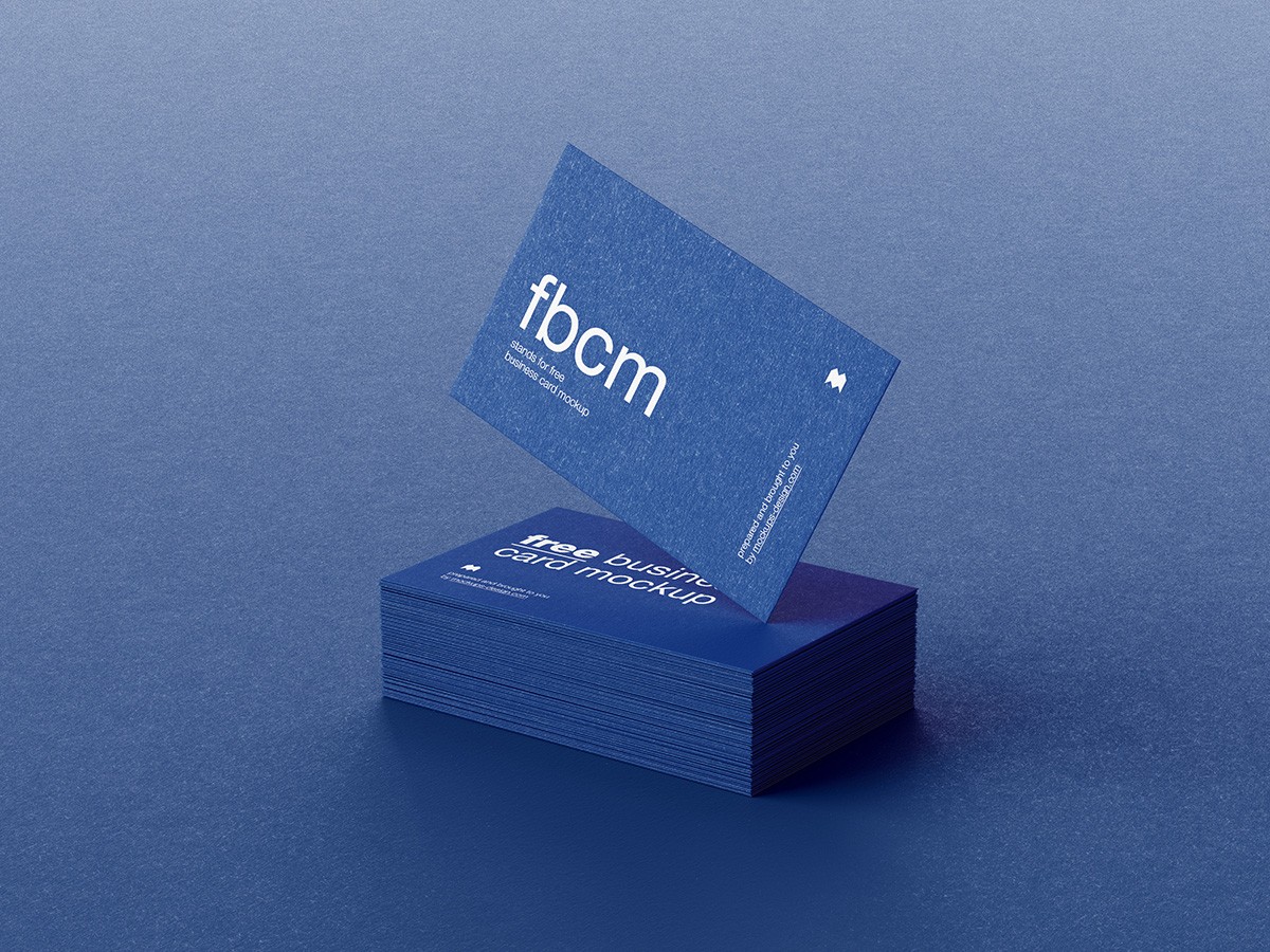 A stack of blue business cards on a blue surface, with one card prominently displayed vertically, highlighting bold white text: "fbcm." Minimal, professional.