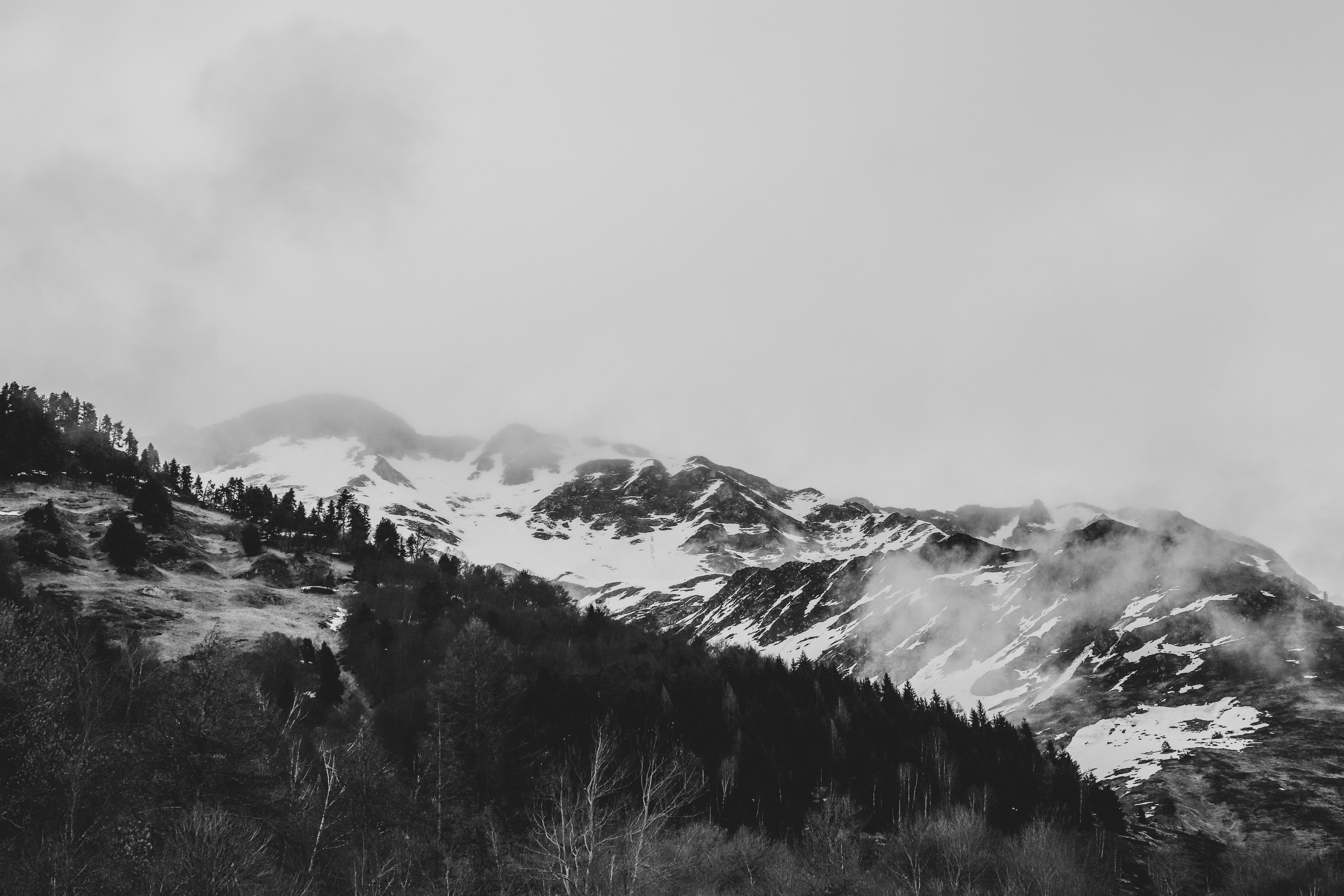 snow covered mountain under grey sky