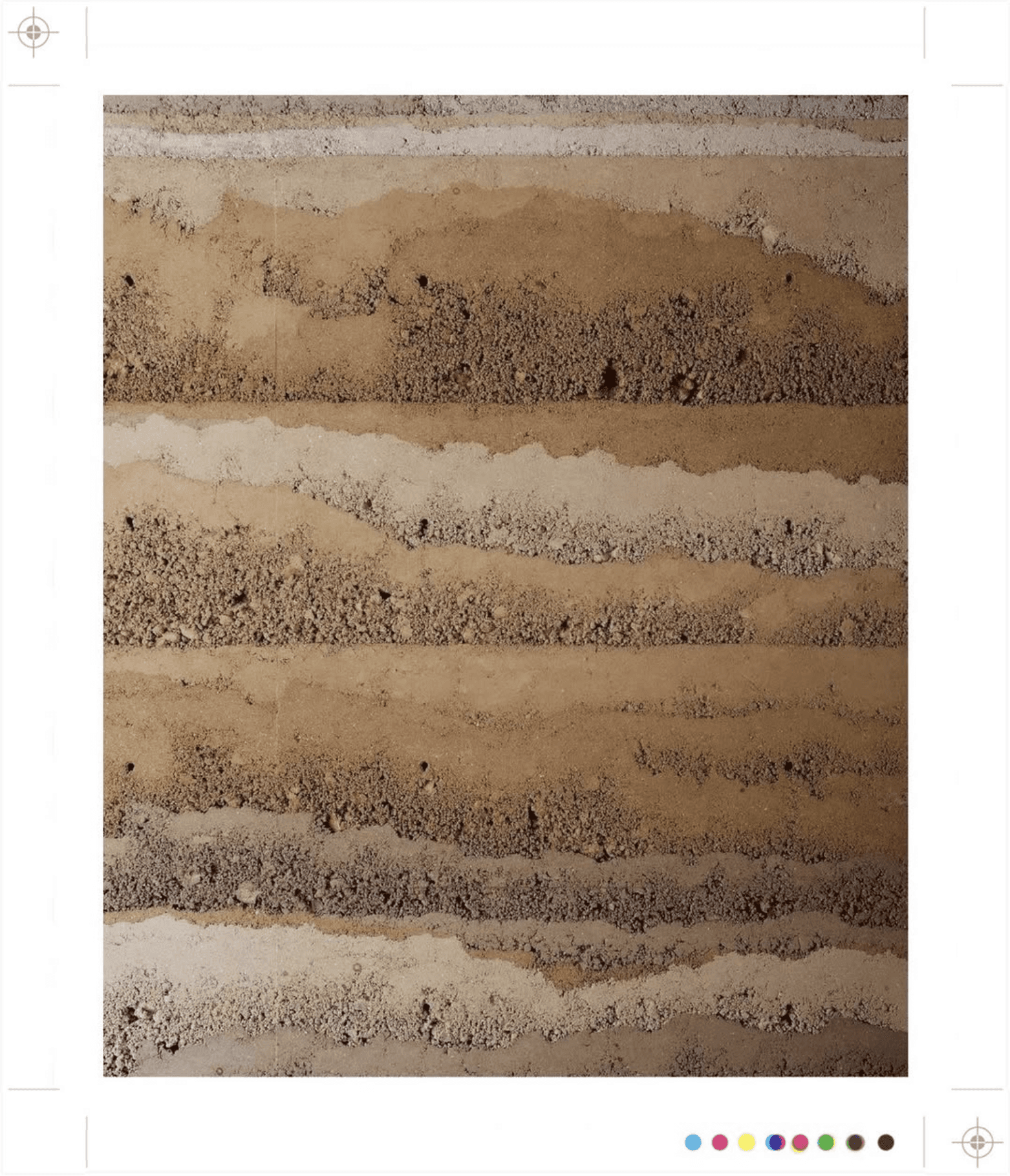 Gelaagde aarden muur met verschillende tinten bruin en beige.