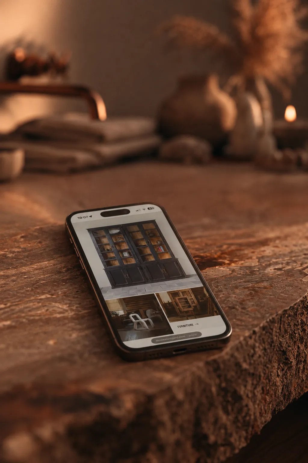 Nicole’s Lantgård furniture collection displayed on a smartphone resting on a textured stone surface.