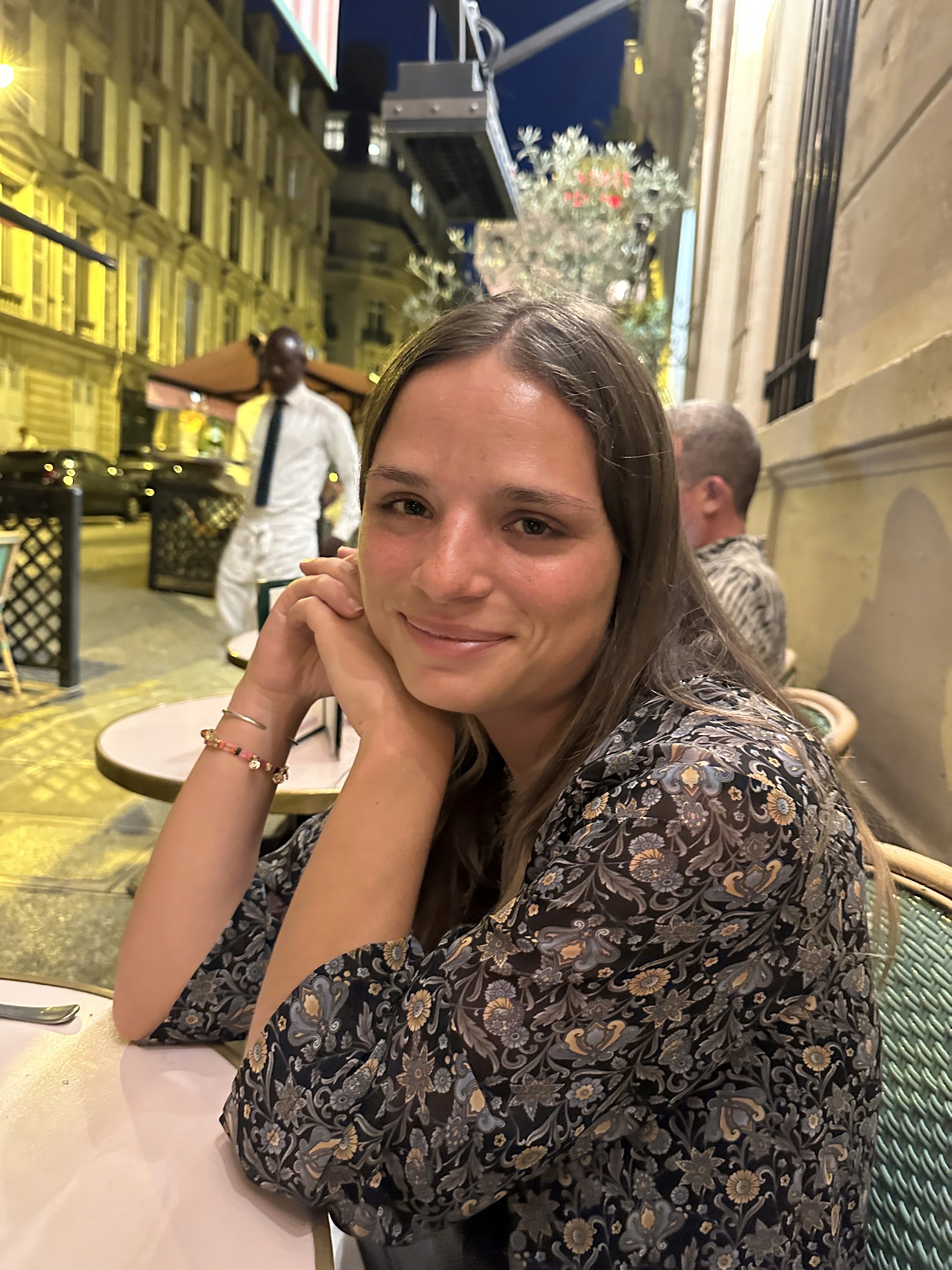 A woman poses gracefully in a white dress.