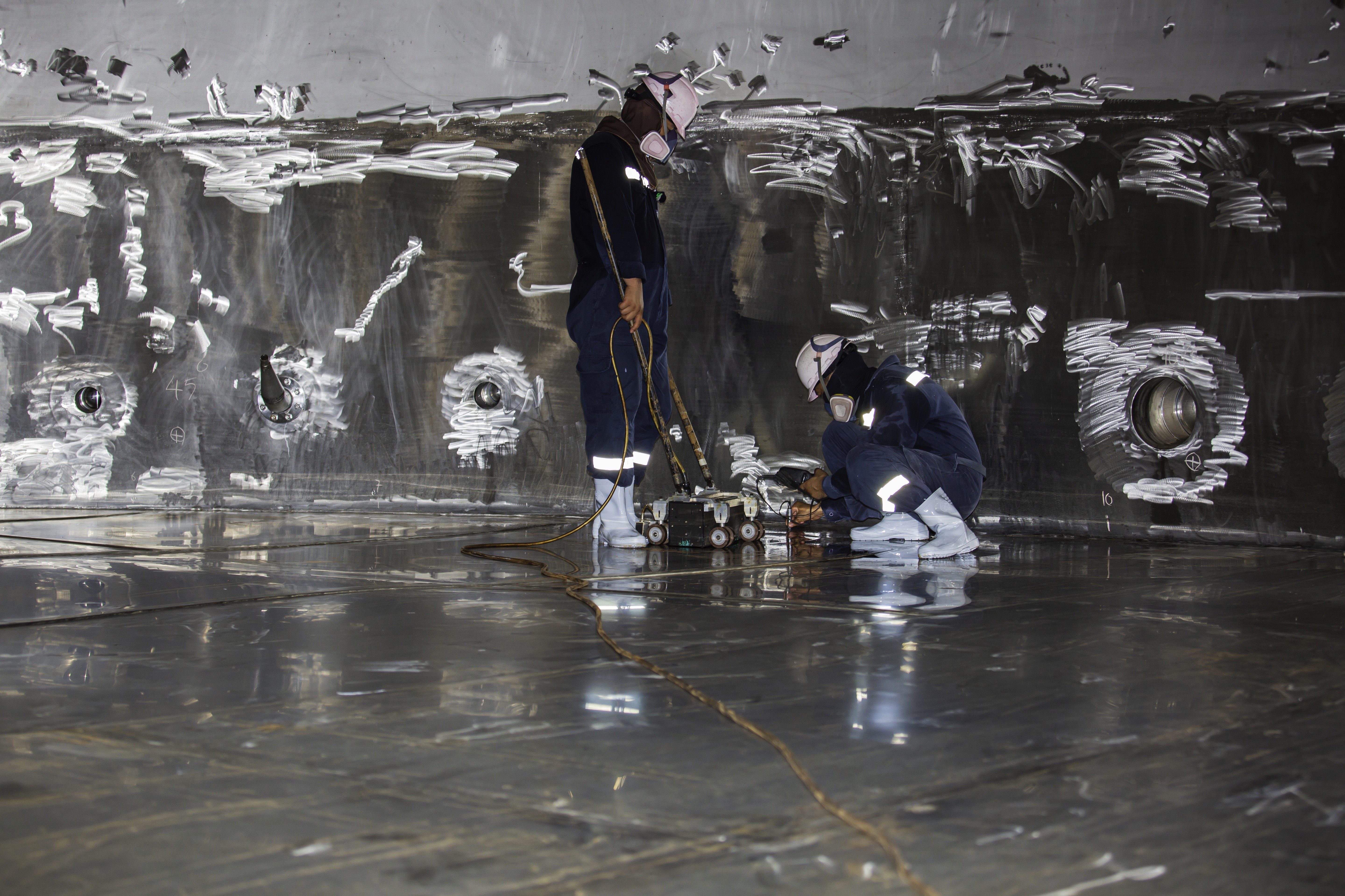 Aerial view of a winding road cutting through rocky terrain and sandy landscape.