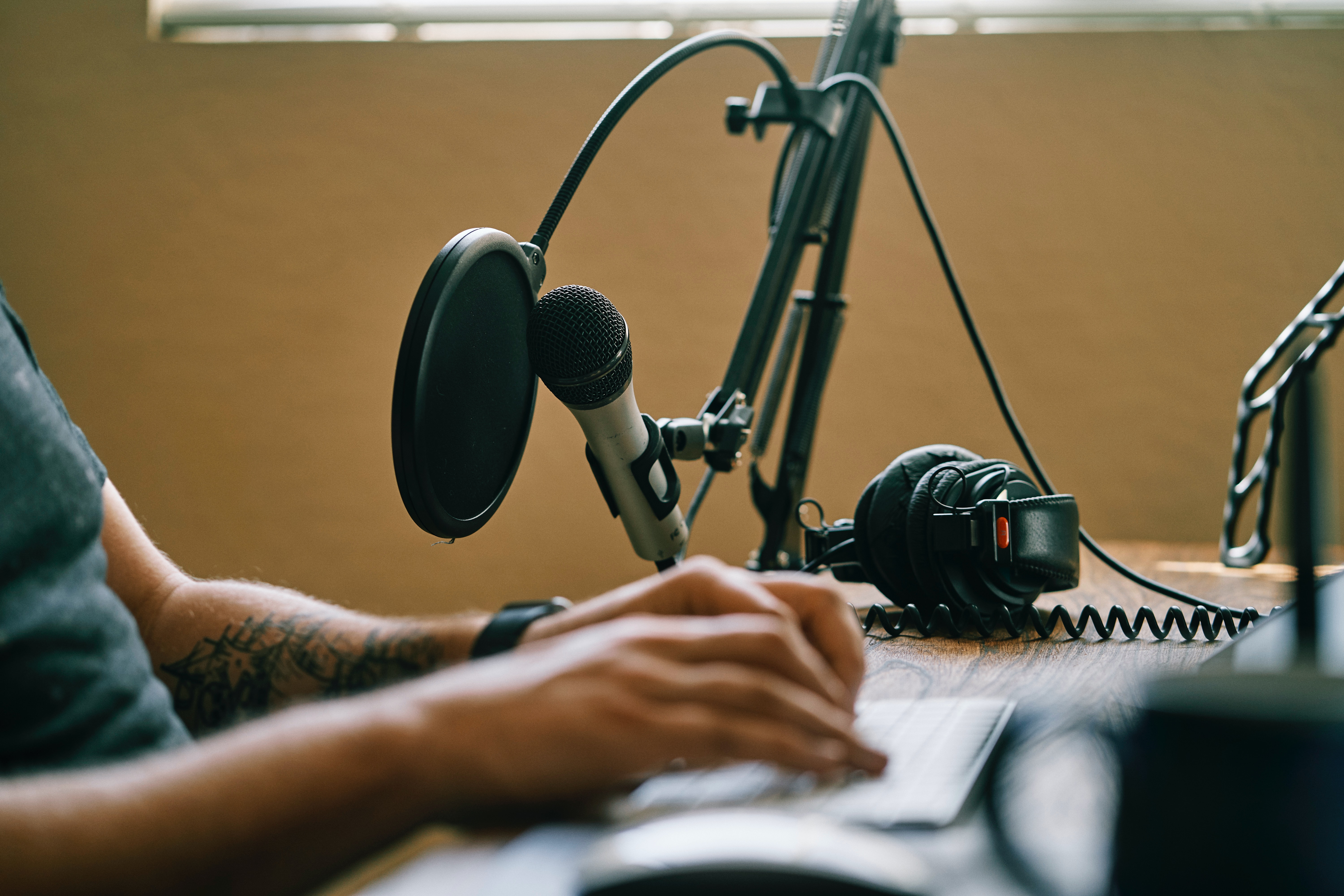 man infront of laptop with notepad to find vocalists online