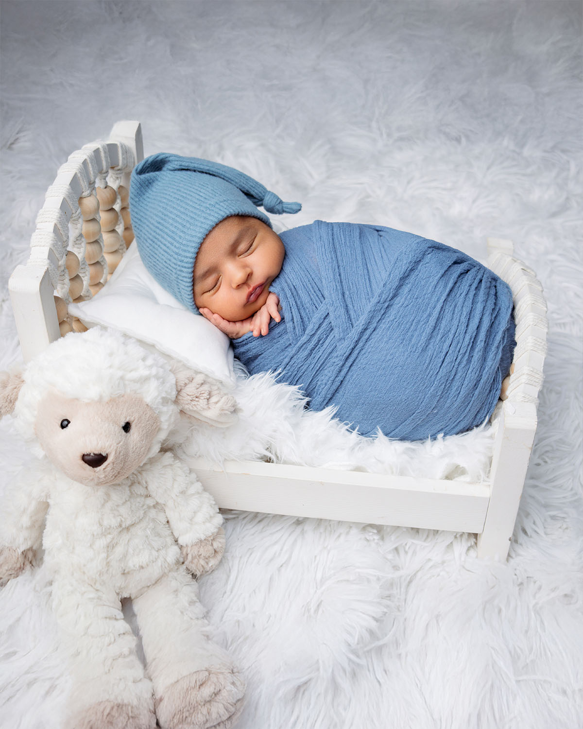 Close-up newborn photo highlighting baby’s tiny hands and peaceful face.