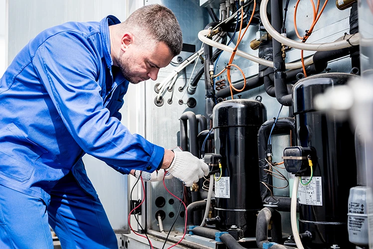Blurred background image of an HVAC technician's hands carefully repairing the internal components of a heating unit.