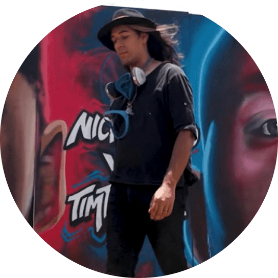 artist walking in front of mural