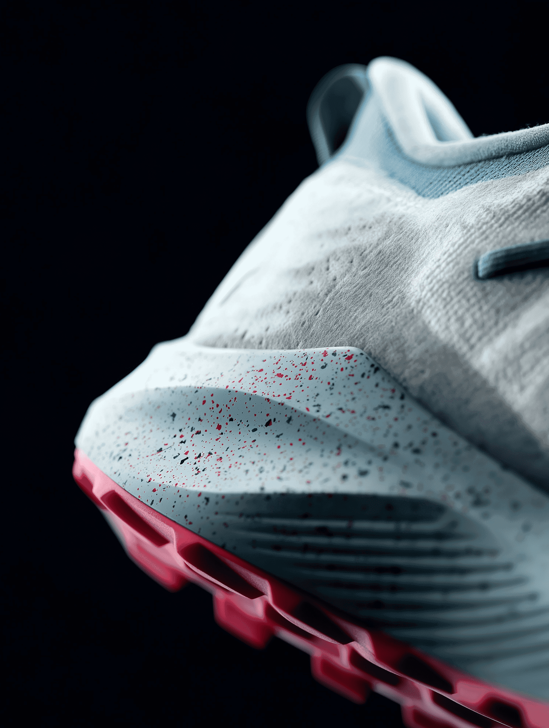 Close-up detail of a modern athletic shoe with red outsole and textured upper