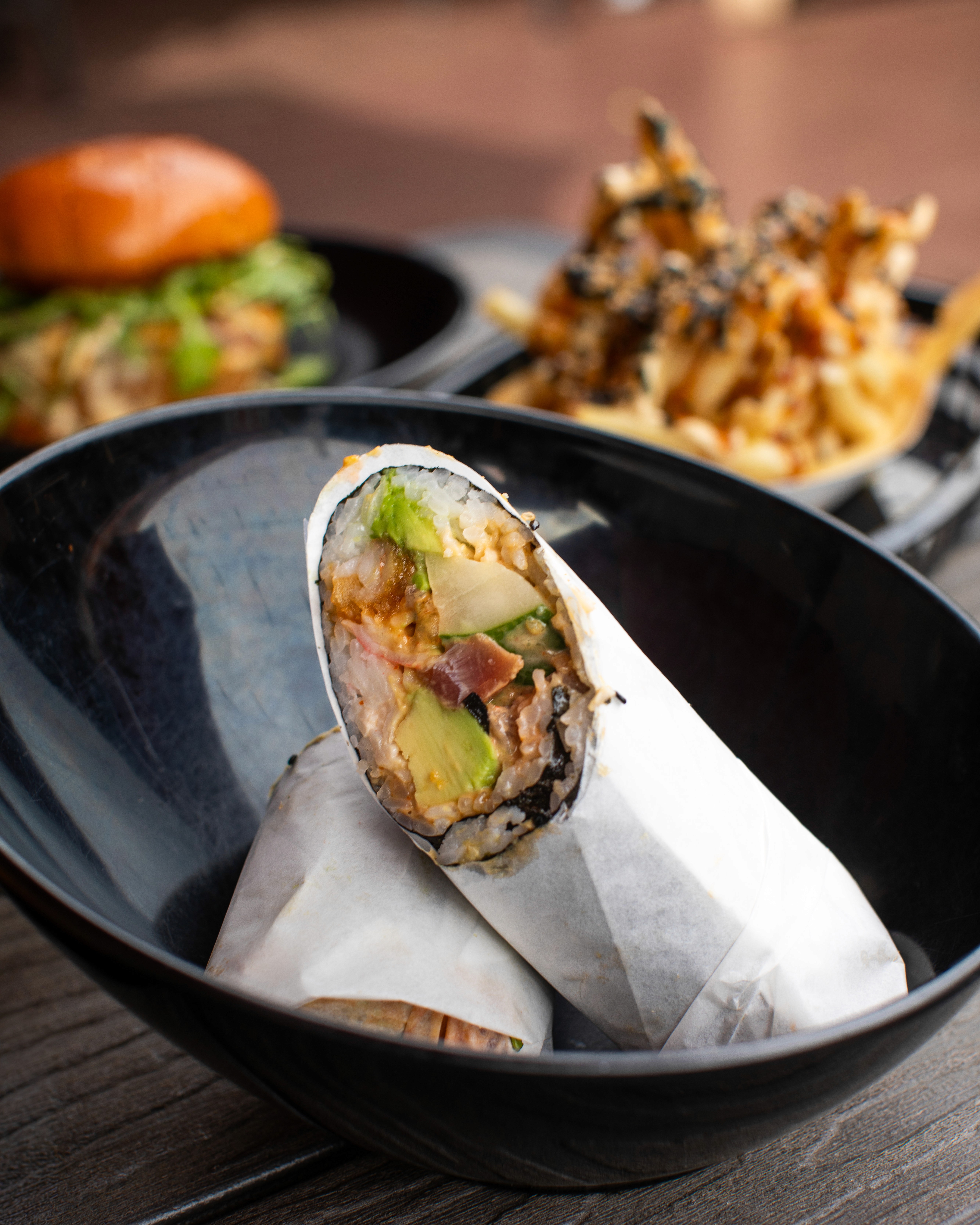 A hearty holiday side dish, possibly a potato salad or mash mixed with greens and herbs, heavily garnished with fresh dill, served on a gray plate amidst a festive table setting with fir branches and a lit candle.