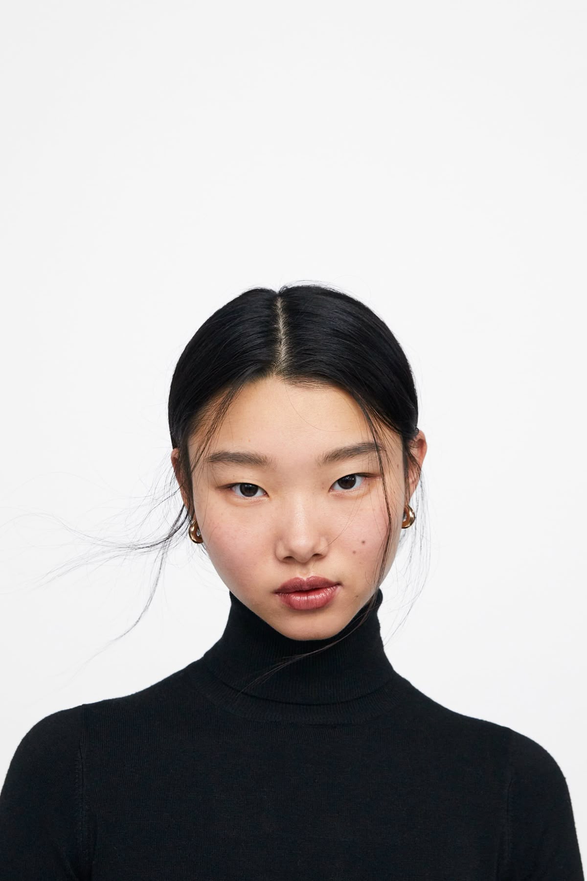Portrait of an Asian woman wearing a black turtleneck.