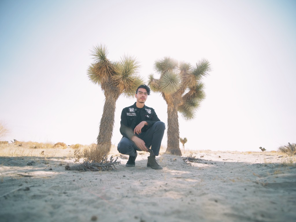 Self portrait of Juan Abad with a couple of Joshua trees behind him