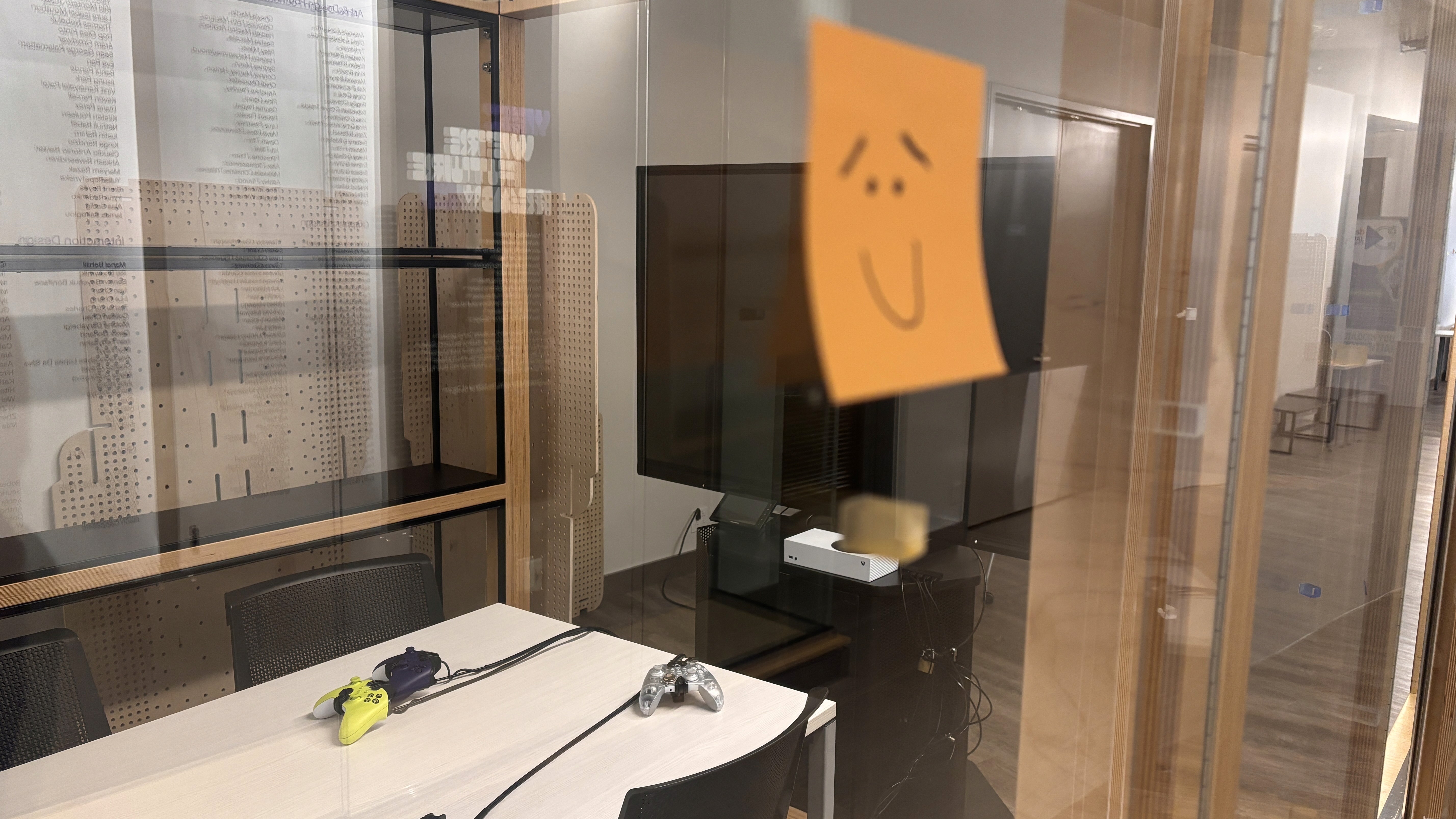 looking at video game setup through plastic window with orange sticky note