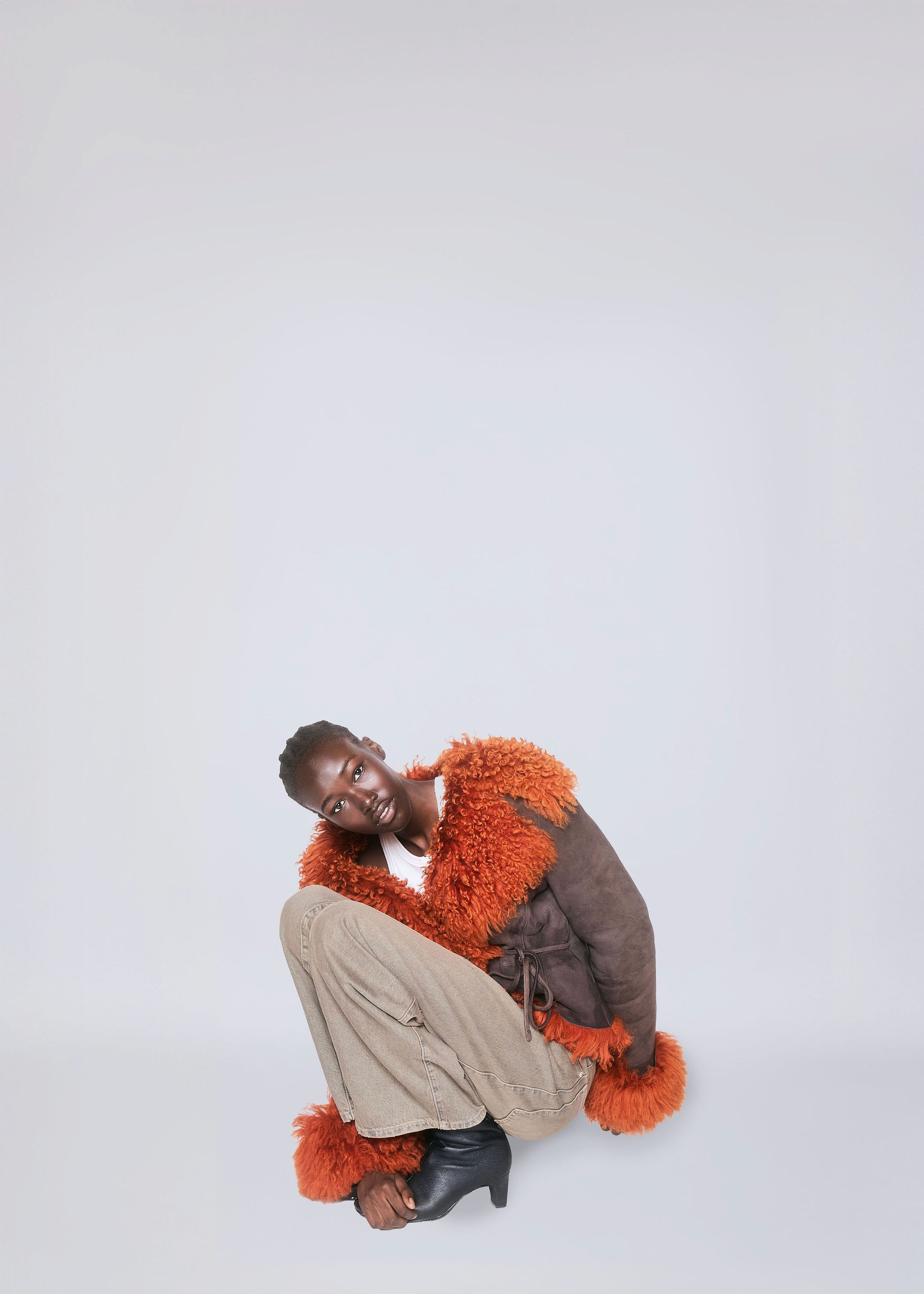 Young woman with dark hair and bangs, wearing red.