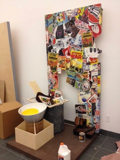 wooden structure with stickers and images glued to it and miscellaneous objects