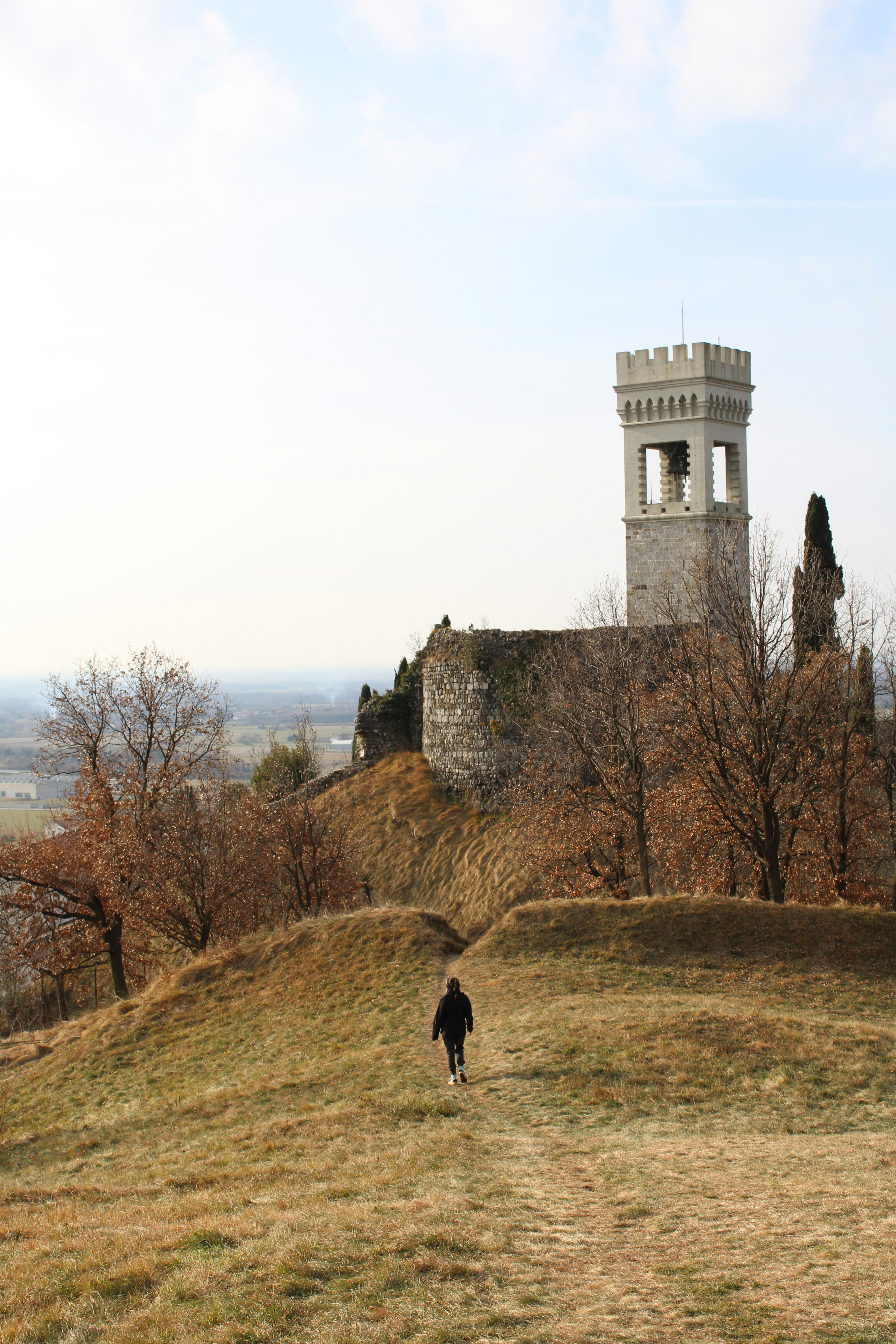sitting woman carrying backpack overlooking canyon during daytime