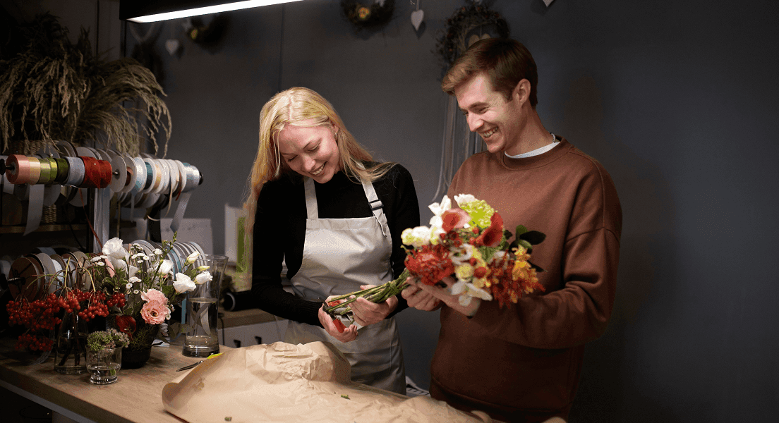 A group of four people engaged in a discussion while seated in a cozy, plant-filled setting.