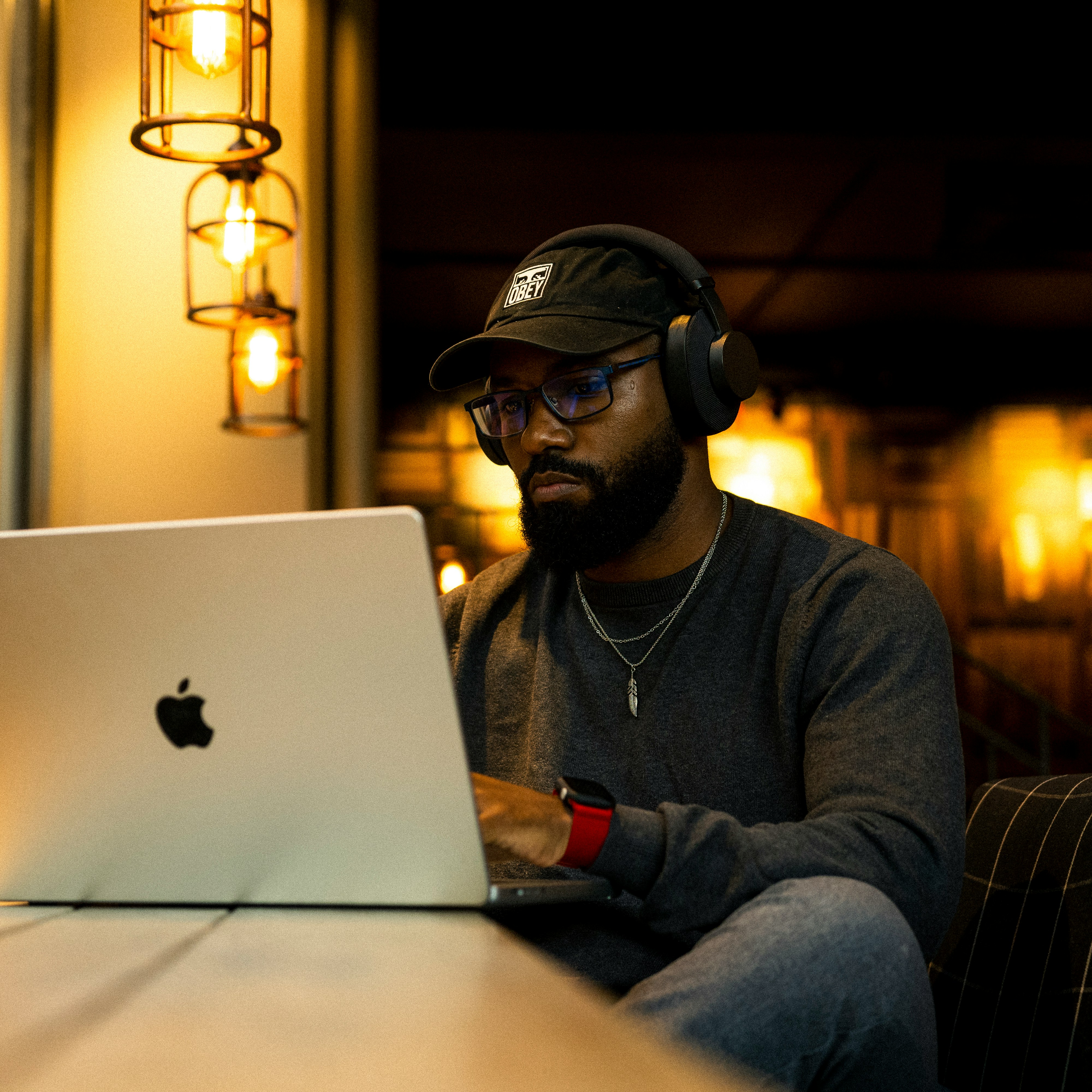 Man working on a laptop in a dimly lit room.