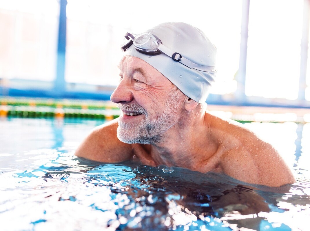older man smiling after best pool exercises for weight loss after noticing that he has higher stamina