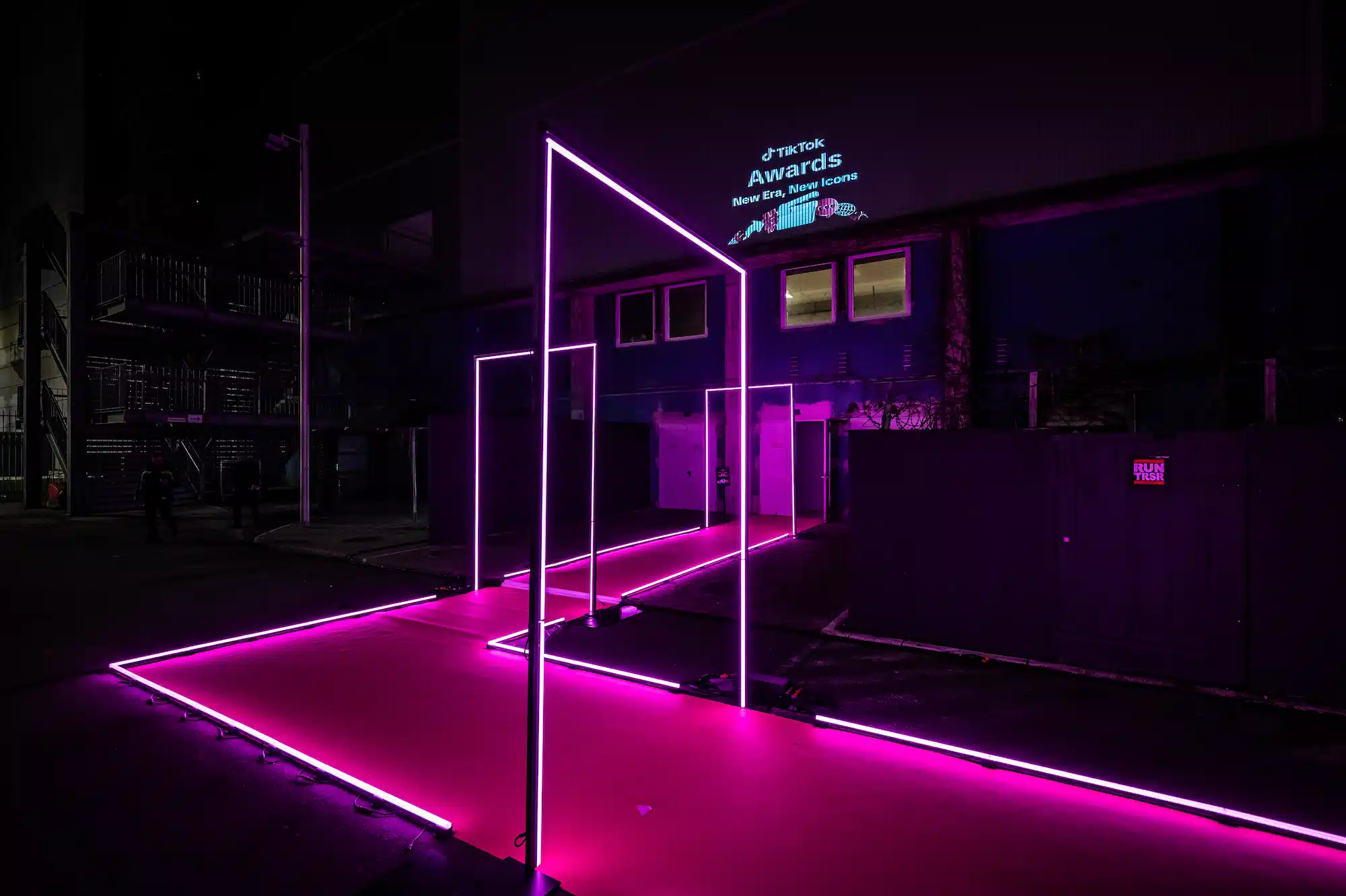 TikTok Awards – exterior entrance with pink neon frame arches and TikTok Awards projection on building facade