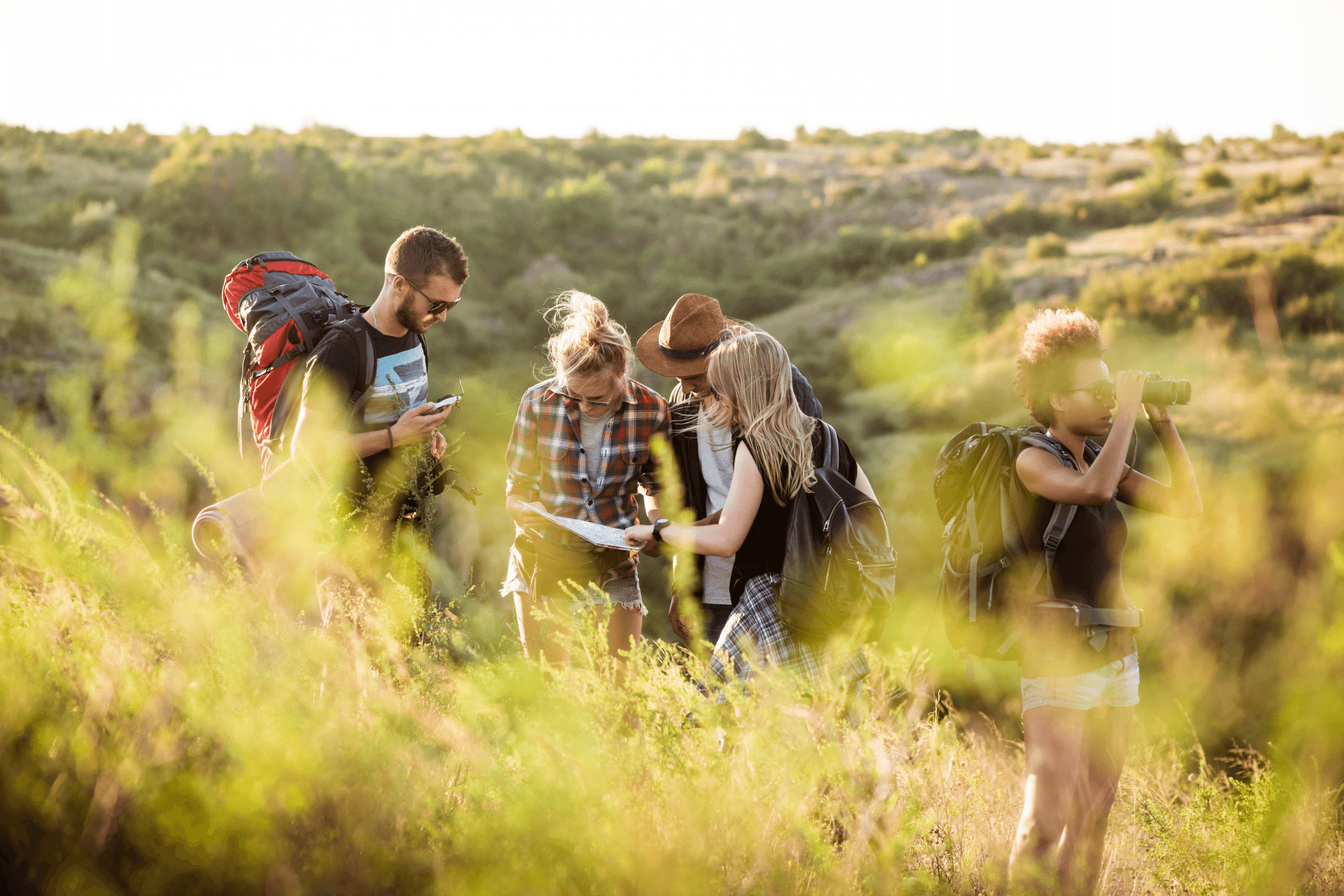 Group of friends hiking on a grassy mountain trail