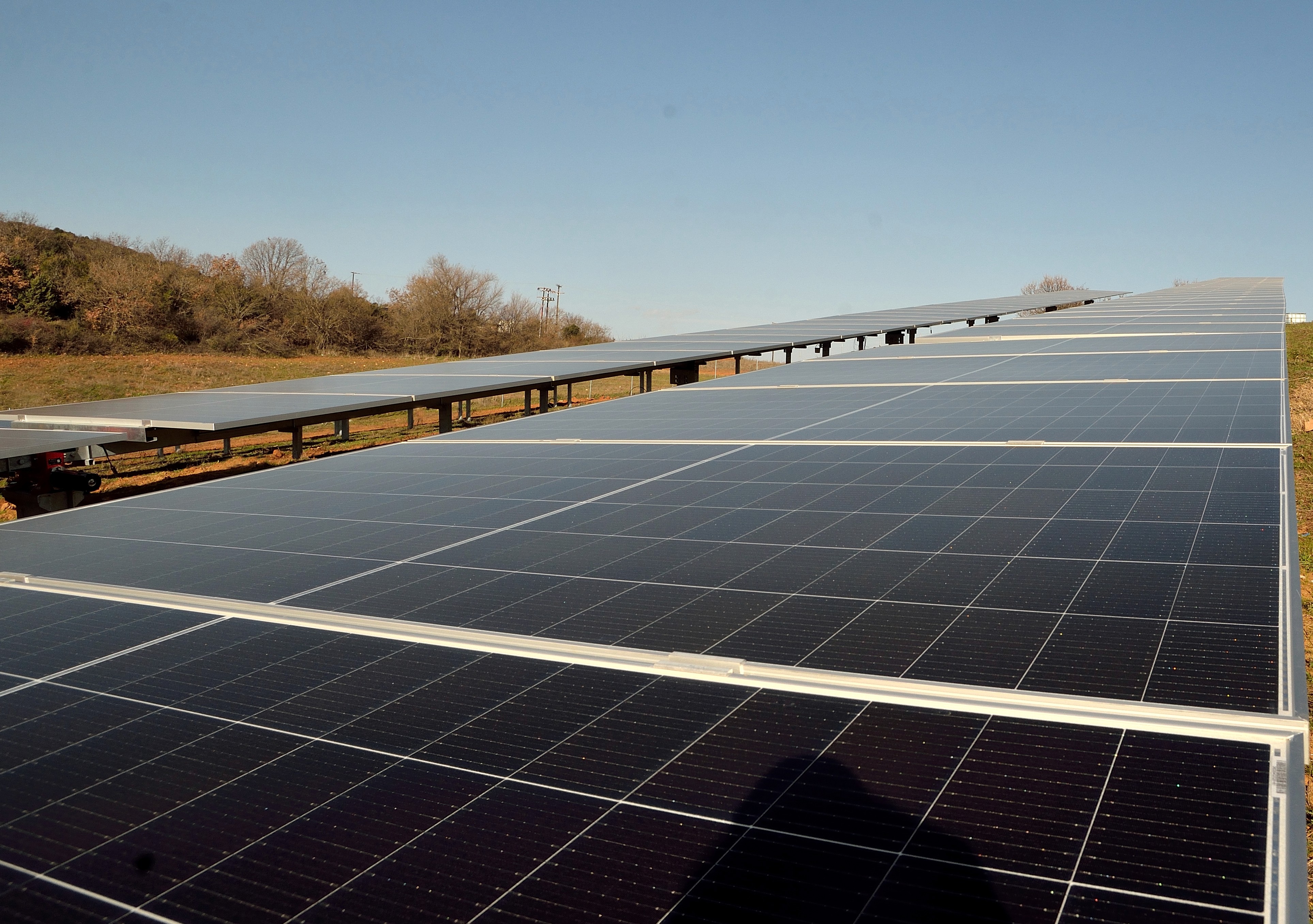 Low-angle view of photovoltaic panel rows showing alignment and surface of solar modules
