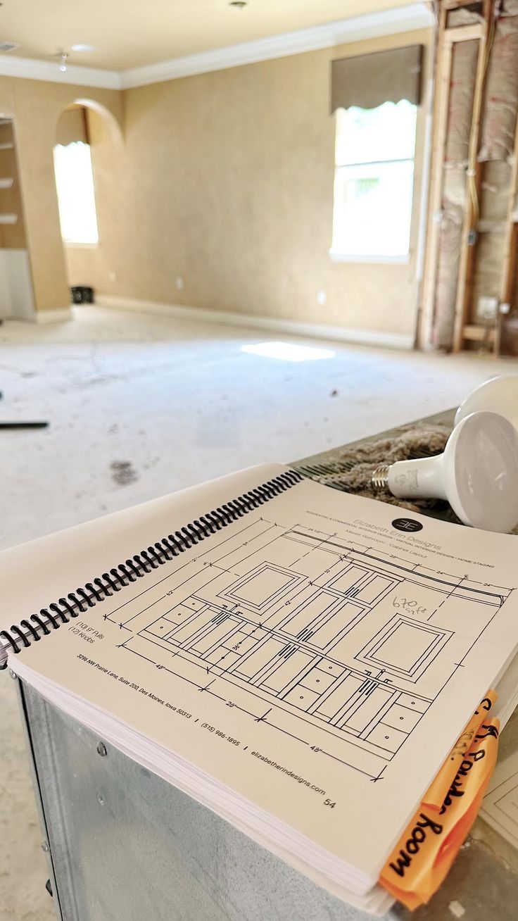 A modern house with large windows and a flat roof, surrounded by greenery against a clear blue sky.