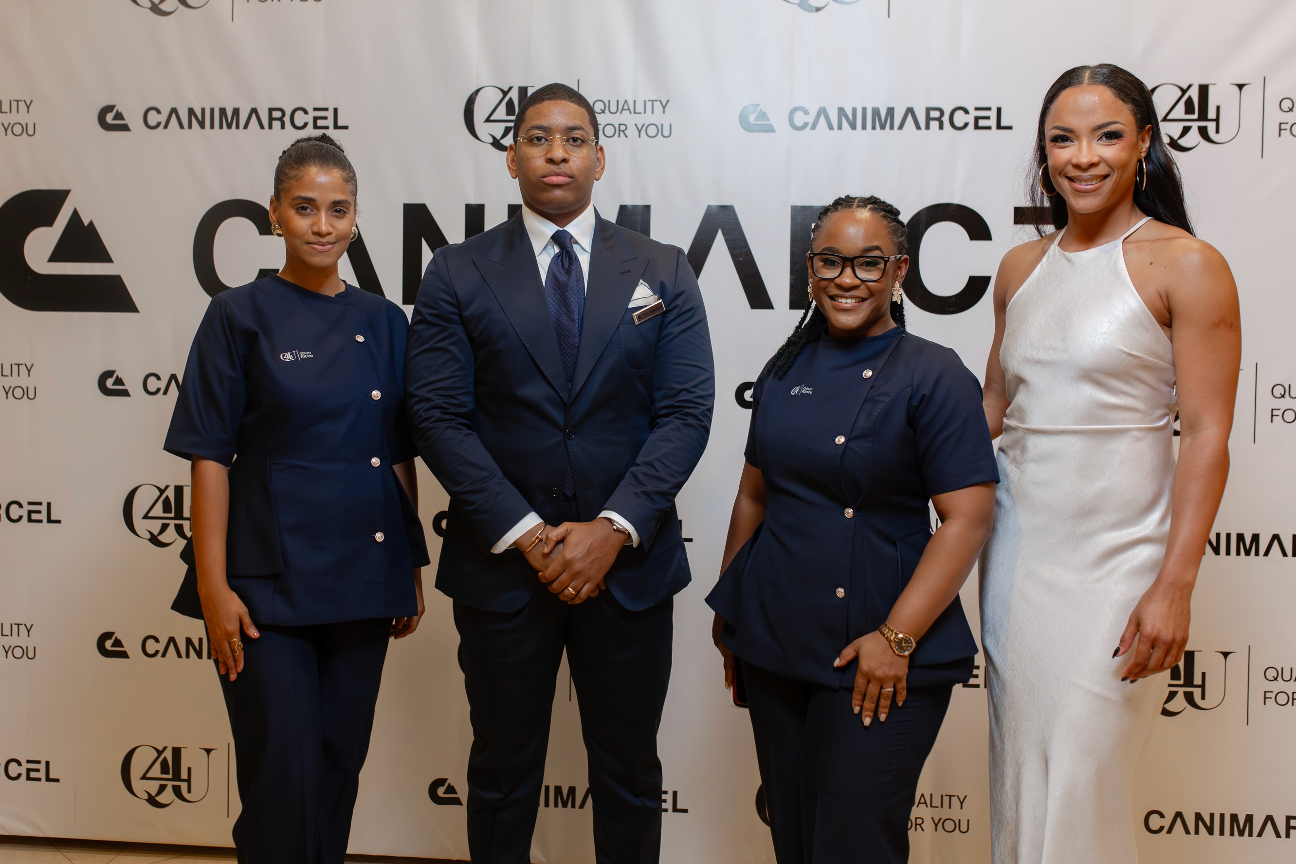 Two people review colorful charts with graphs, pie charts, and diagrams on paper and screens. A notebook lies open nearby. The mood is analytical.