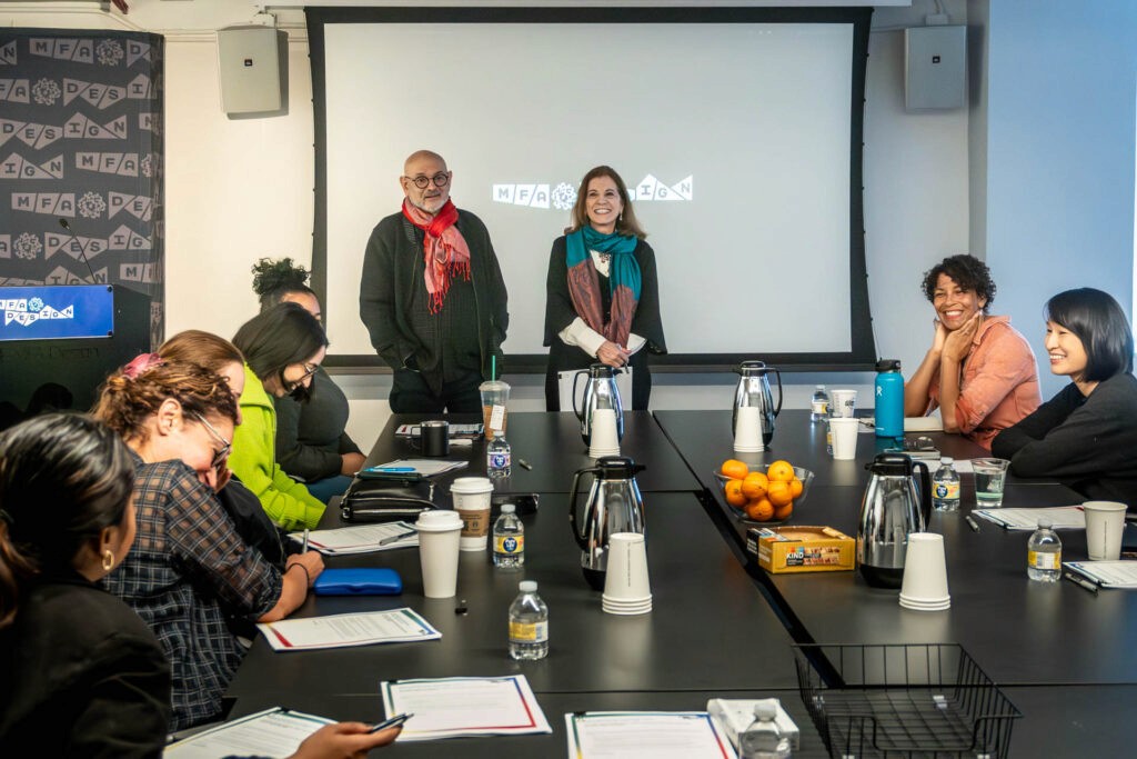 two people giving a presentation to a room of people at tables