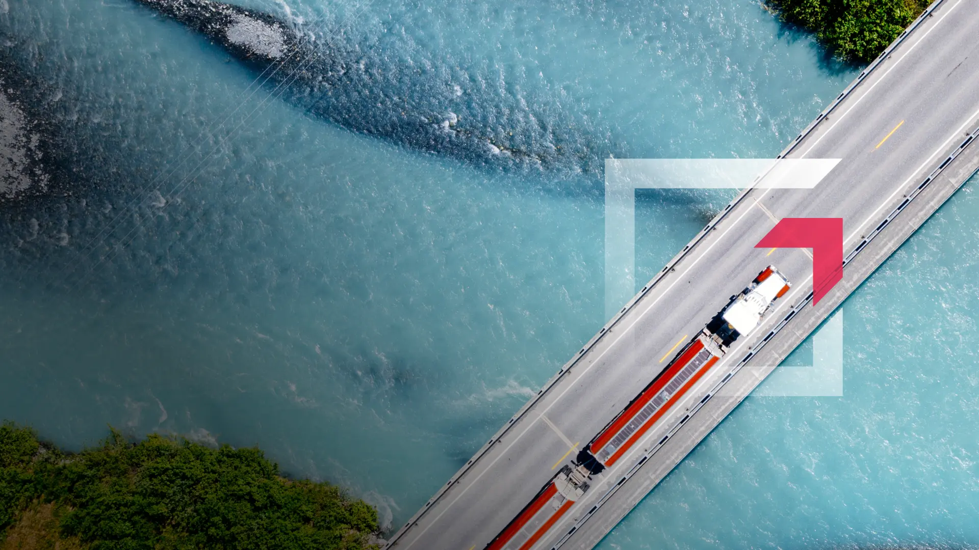 Aerial view of a semi-truck driving across a bridge over blue water representing commercial truck insurance services by GIA Group, LLC