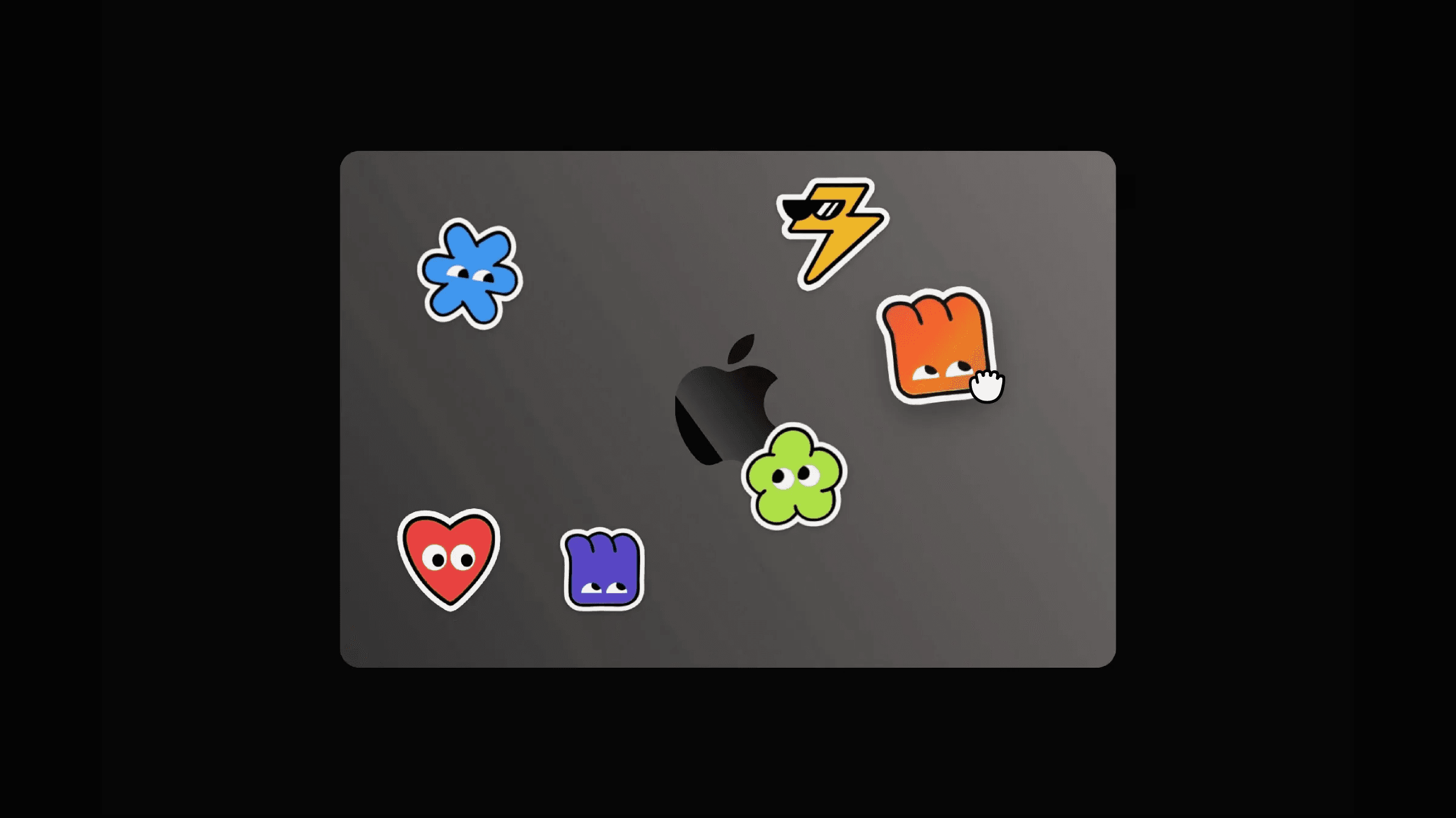 ⁠MacBook lid with colorful cartoon stickers and cursor