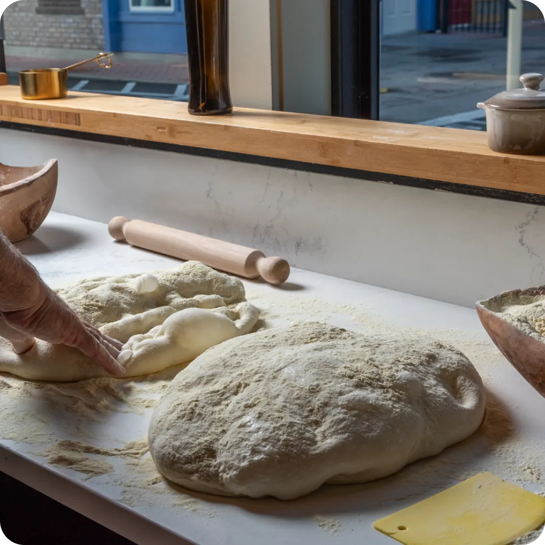 Baker preparing pizza dough by hand