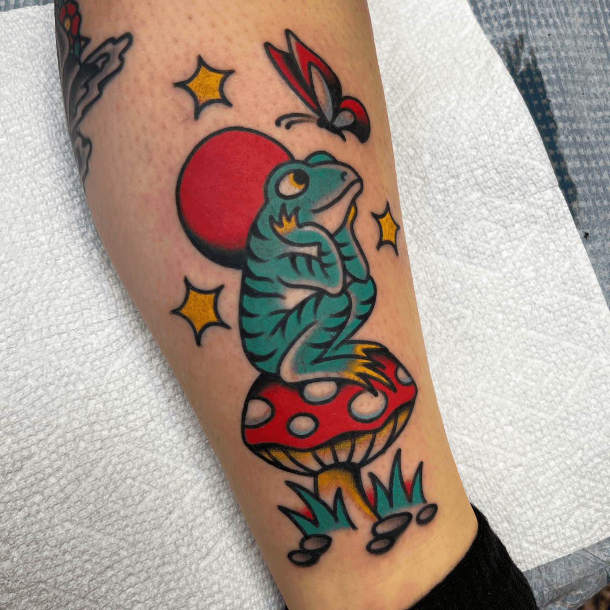 color tattoo of a frog on a mushroom with a butterfly and moon