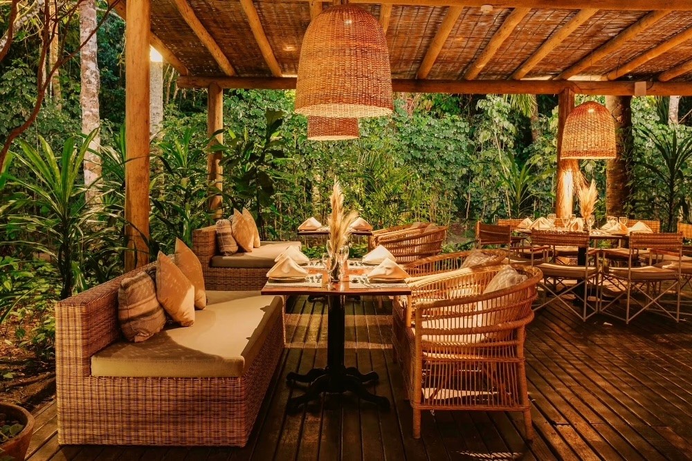 A serene pathway lined with trees leads to a distant building, bathed in warm sunlight.