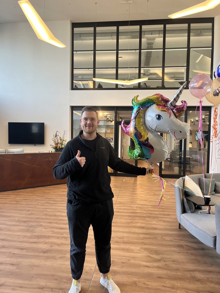 Man holding a unicorn balloon.