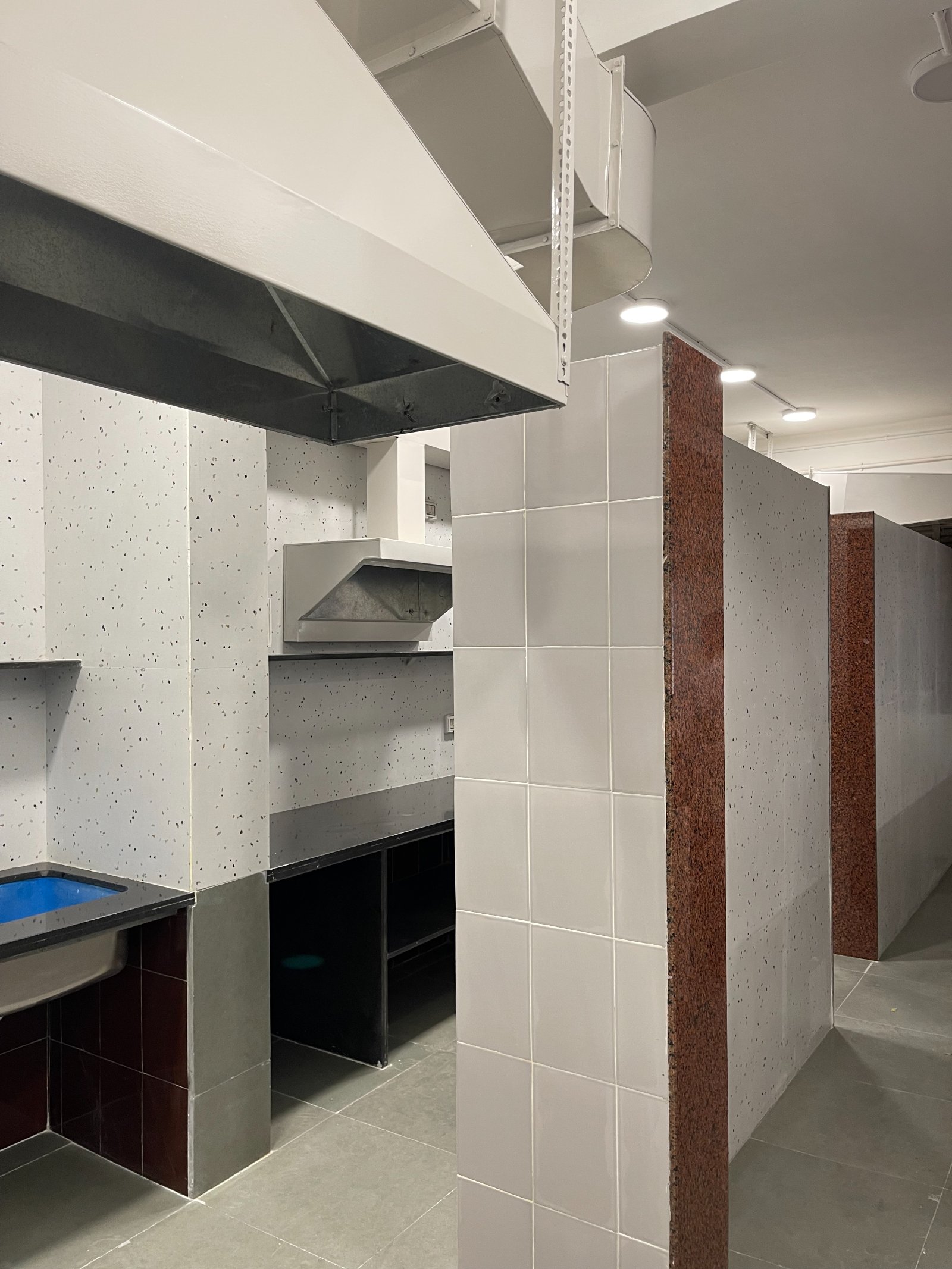 Nature-inspired preschool entrance with sculptural tree partitions and suspended green leaf ceiling panels.