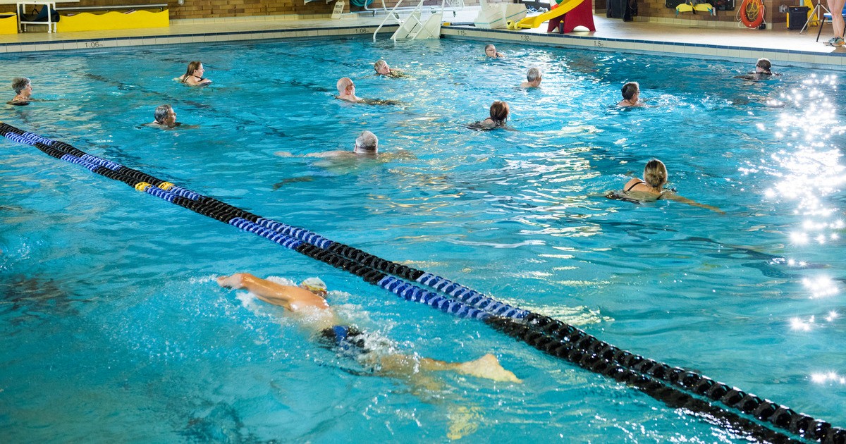 Swimmers doing laps in an indoor pool at a parks and recreation facility managed with TeamLinkt and Amilia